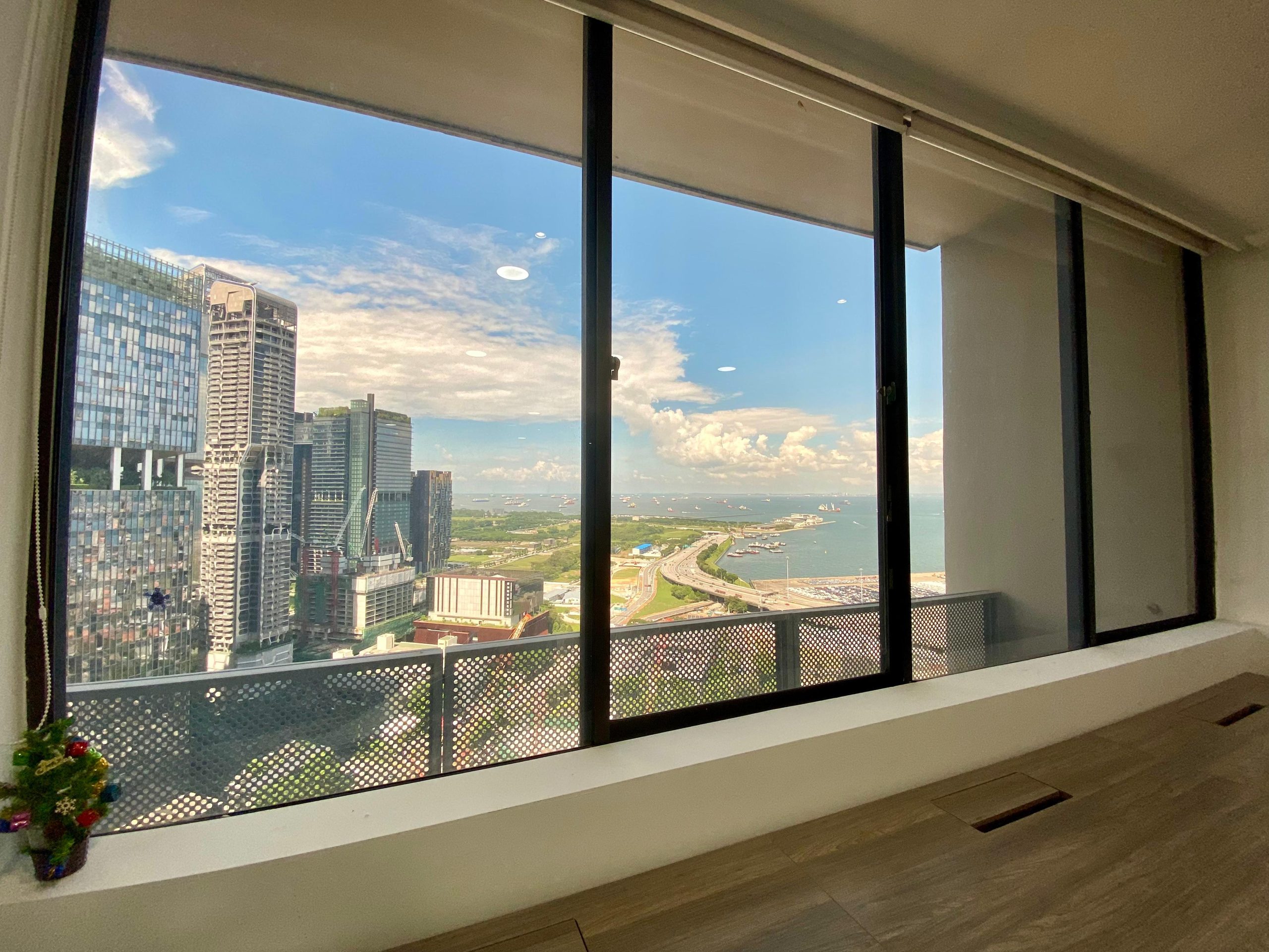 Office window at Penguins Coworking, a coworking space in Singapore CBD, with city and sea views